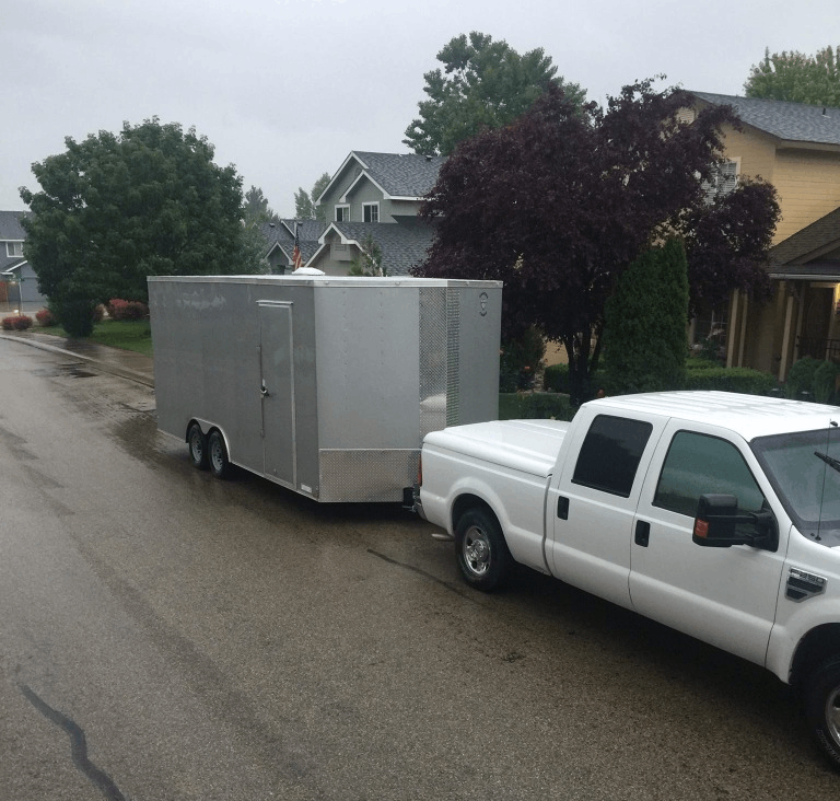 A White Car Towing Cabin on the Road